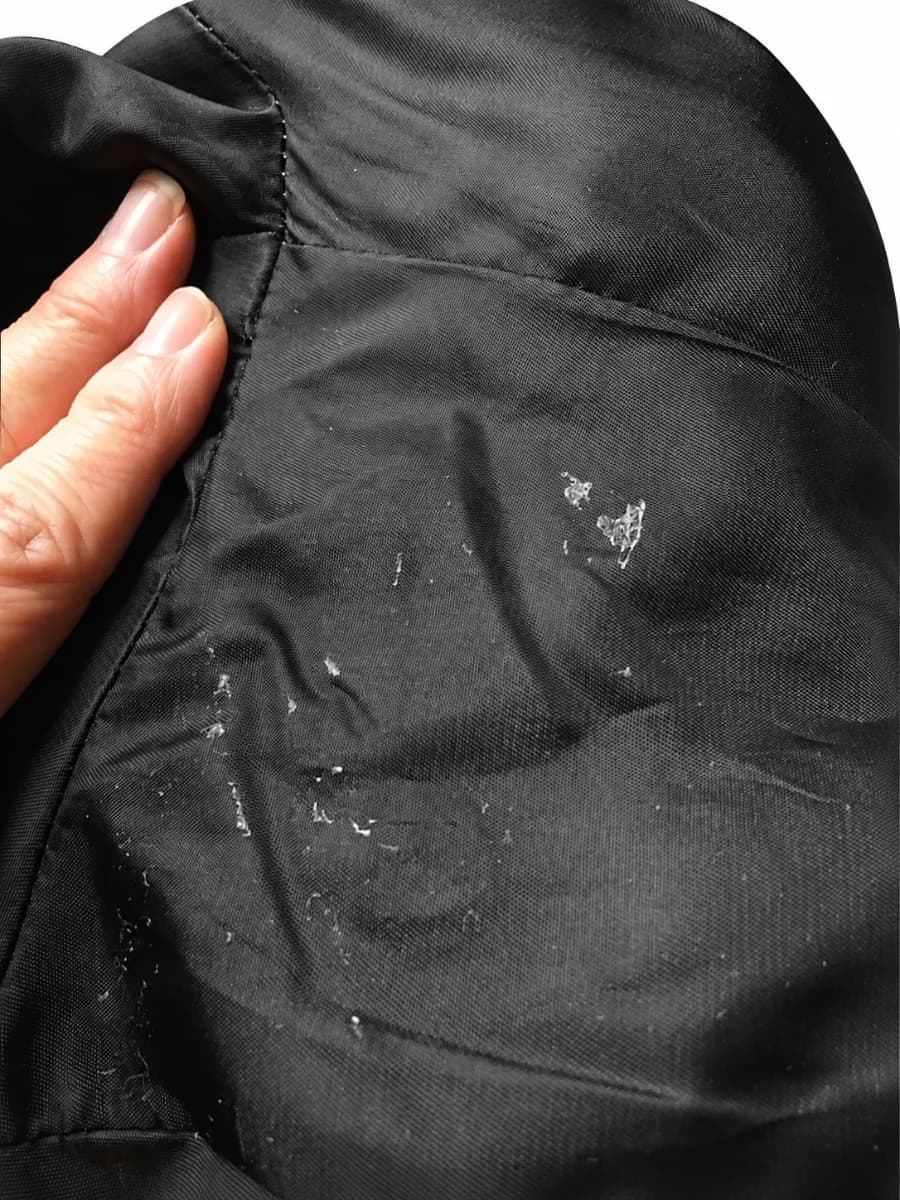 Adhesive residue visible on the garment lining after removal of the documented Kleinert's sample.