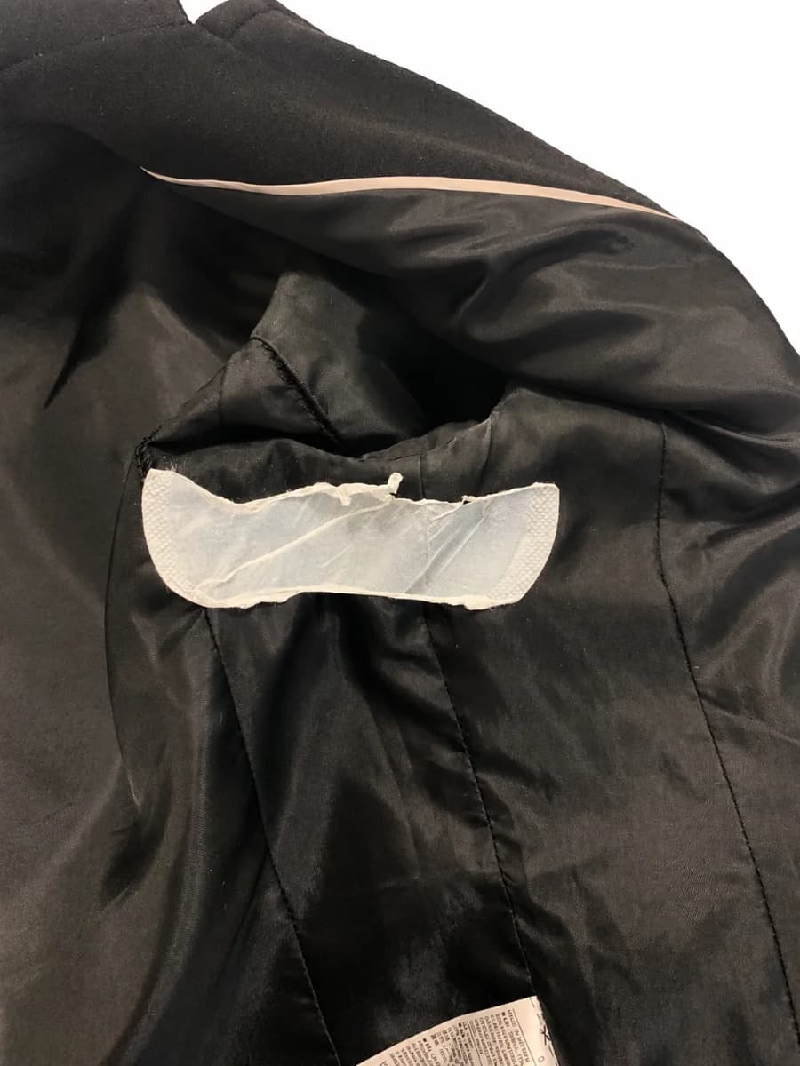 A ragged torn edge on the documented MAQIHAN pad after removal from a garment lining.